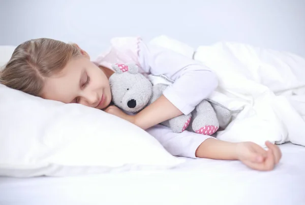 Παιδί κοριτσάκι που κοιμάται στο κρεβάτι με ένα αρκουδάκι παιχνίδι — Φωτογραφία Αρχείου