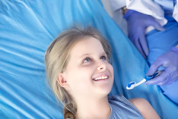 Niña sentada en el consultorio de dentistas — Foto de Stock