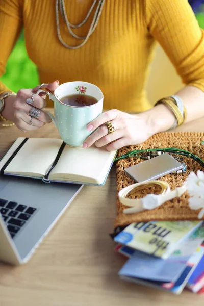 Молодая женщина на кофе-брейке или наслаждается кофе-брейком, используя ноутбук — стоковое фото