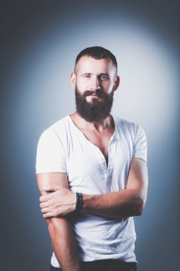 Ayakta, gri arka plan üzerinde izole yakışıklı adam portresi