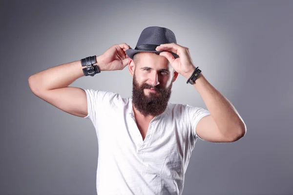 Retrato de hombre barbudo guapo con sombrero de pie, aislado sobre fondo gris —  Fotos de Stock
