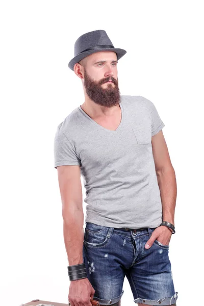 Портрет красивого бородатого чоловіка в капелюсі стоїть, ізольований на сірому фоні — стокове фото