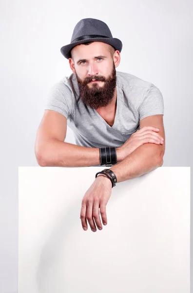 Portrait of young man in hat standing near blank, isolated on white background