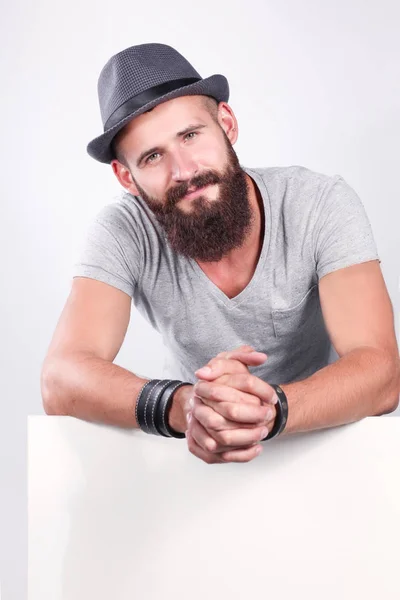 Retrato de jovem de chapéu em pé perto de branco, isolado sobre fundo branco — Fotografia de Stock