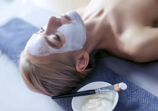 Mascarilla facial. Hermosa joven en el spa, mujer cosmética aplicando mascarilla facial —  Fotos de Stock