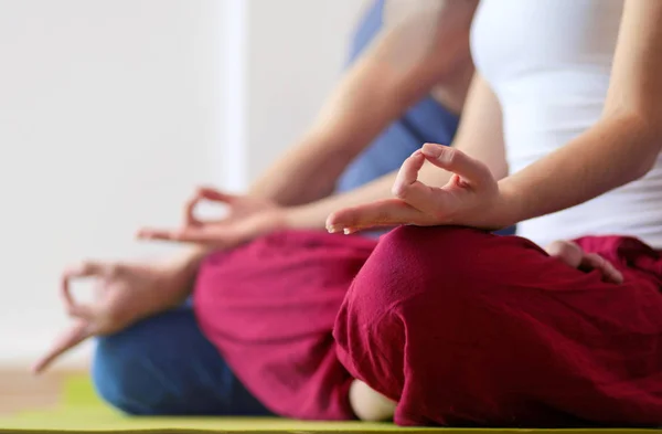 Joven pareja sana en posición de yoga sobre fondo blanco — Foto de Stock