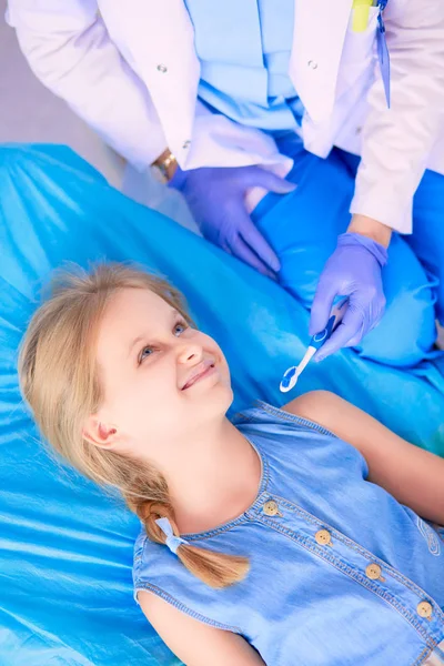 Niña sentada en el consultorio de dentistas — Foto de Stock