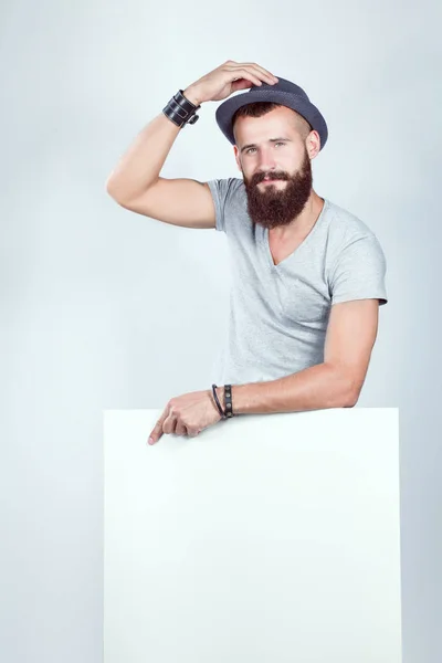 Retrato de un joven con sombrero de pie cerca del blanco, aislado sobre fondo blanco —  Fotos de Stock