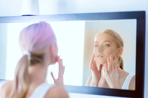 La bella ragazza con una pelle fresca pulita tocca con una mano una guancia — Foto Stock