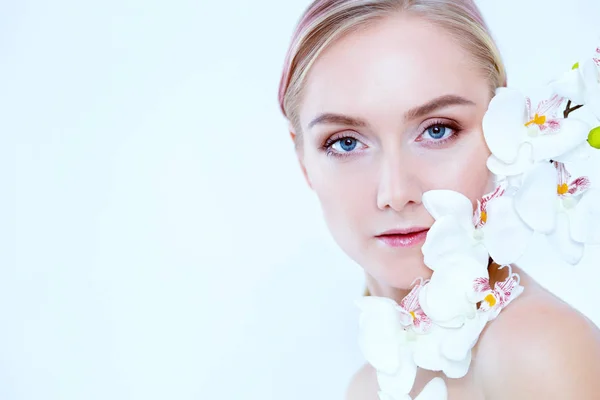 Unga skönhet kvinna med blomma nära ansikte — Stockfoto
