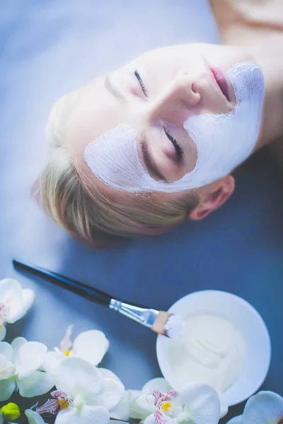 Gezichtsmasker. Mooi jong meisje in spa, schoonheidsspecialist vrouw gezicht masker toe te passen — Stockfoto