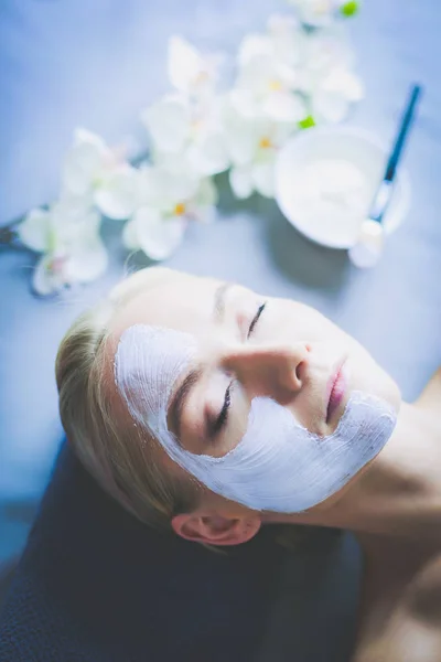 Ansiktsmask. Vacker ung flicka på spa, cosmetician kvinna tillämpa ansiktsmask — Stockfoto