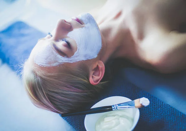 Ansiktsmask. Vacker ung flicka på spa, cosmetician kvinna tillämpa ansiktsmask — Stockfoto