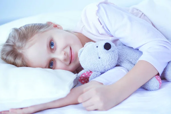 Kleines Mädchen schläft im Bett mit einem Spielzeug-Teddybär — Stockfoto