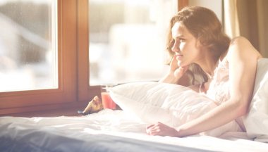 Güzel bir kadın yatağında uzanıyor.