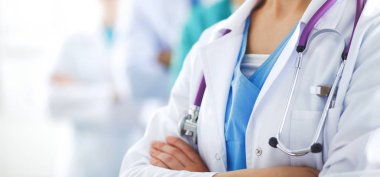Kadın doktor hastanede steteskopla dikiliyor.