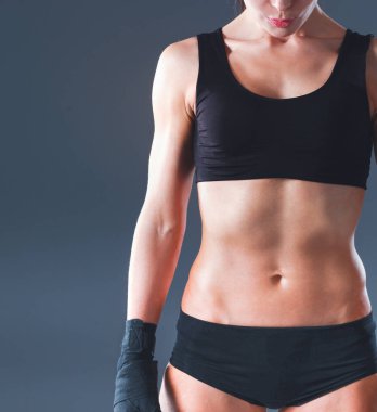 gri arka plan üzerinde duran kas genç kadın