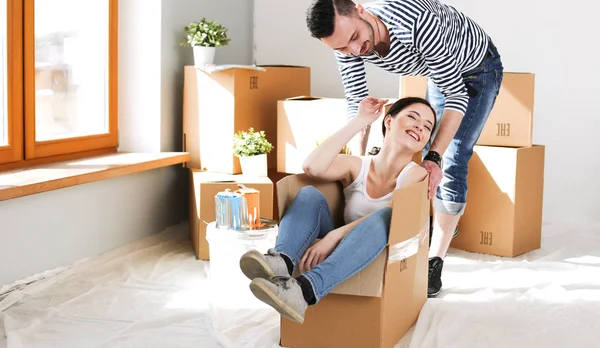 Счастливая молодая пара распаковывает коробки и переезжает в новый дом — стоковое фото