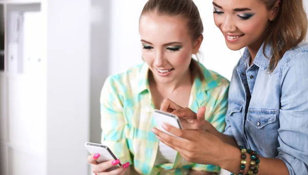 Zwei Frauen, die zusammen im Büro am Schreibtisch sitzen — Stockfoto