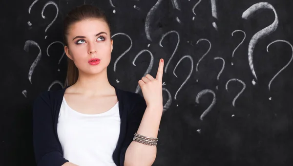 Young girl with question mark on a gray background — Stock Photo, Image