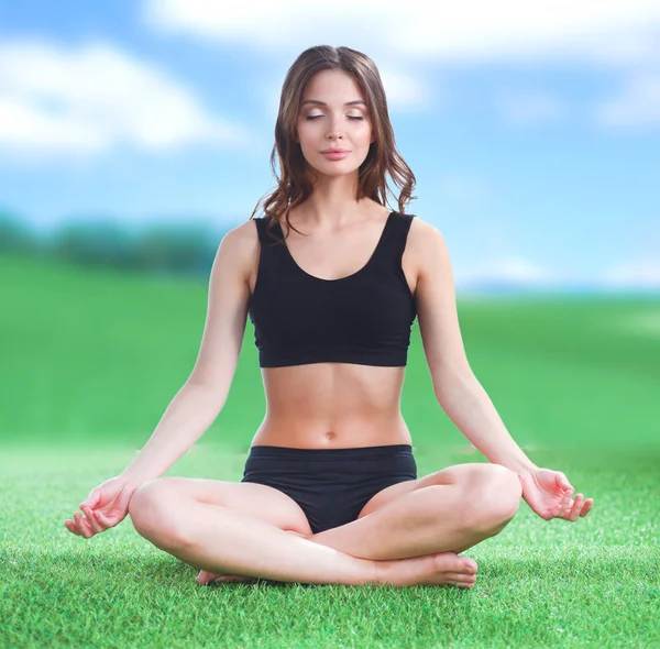 Młoda kobieta praktykowania jogi w pozycji lotosu — Zdjęcie stockowe