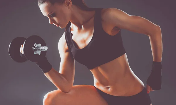 Athletic woman pumping up muscules with dumbbells — Stock Photo, Image