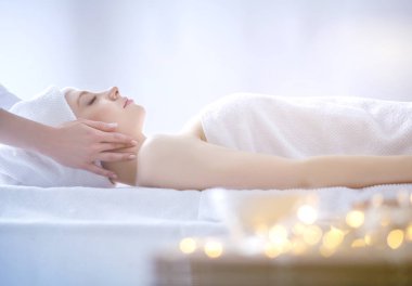 Masaj masasında uzanmış gözleri kapalı rahatlayan genç bir kadın. - Kadın. Spa salonu