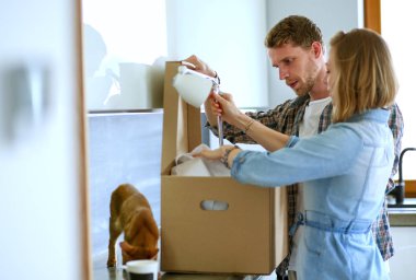 Genç bir çift yeni evde büyük karton kutu taşıyan. Ev taşıma. Genç Çift