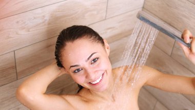 Genç beautyful kadın banyoda duş altında.