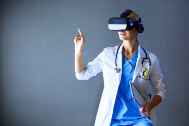 Sanal gerçeklik gözlüğü takan kadın doktor beyaz arka planda izole edilmiş..