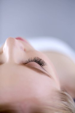 Masaj masasında uzanmış gözleri kapalı rahatlayan genç bir kadın. - Kadın. Spa salonu