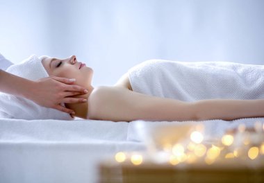 Masaj masasında uzanmış gözleri kapalı rahatlayan genç bir kadın. - Kadın. Spa salonu
