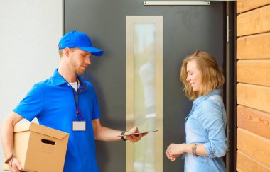 Mavi üniformalı gülümseyen kurye servis konseptine paket kutusu teslim eden teslimatçı. Mavi üniformalı gülümseyen teslimatçı.