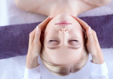 Masaj masasında uzanmış gözleri kapalı rahatlayan genç bir kadın. - Kadın. Spa salonu