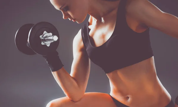 Mujer atlética bombeando músculos con mancuernas — Foto de Stock