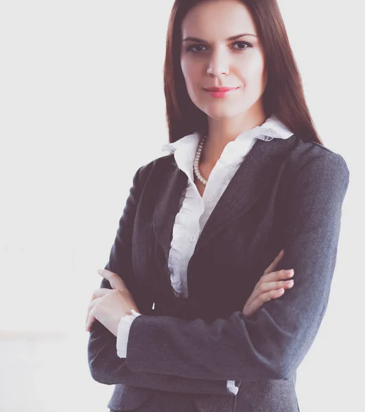 Attractive young businesswoman standing near desk in the office — Stock Photo, Image