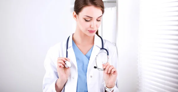 Portrait of young woman doctor with white coat standing in hospital — Stock Photo, Image