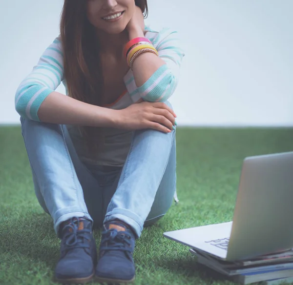 Jeune femme avec ordinateur portable assis sur l'herbe verte — Photo