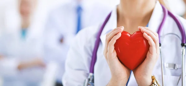 Médica com estetoscópio segurando coração — Fotografia de Stock