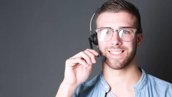 Porträt eines jungen Mannes mit Mikrofon auf grauem Hintergrund — Stockfoto