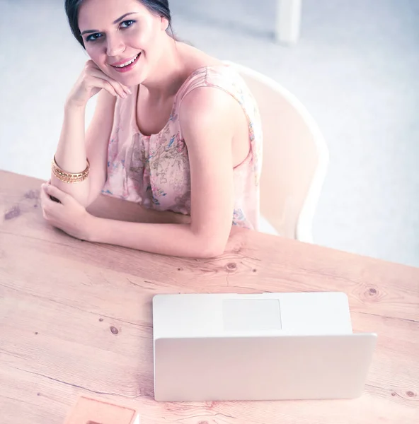 Aantrekkelijke zakenvrouw zit op het bureau in het kantoor — Stockfoto