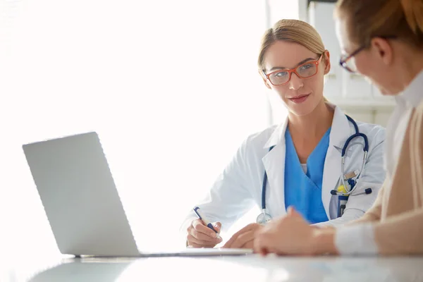Doctor and patient couple are discussing something,sitting on the desk. — Stock Photo, Image