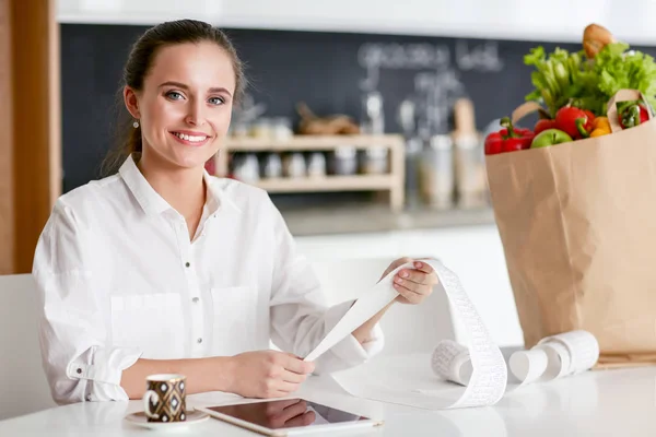 Young woman planning expenses and paying bills on her kitchen. — Stock Photo, Image