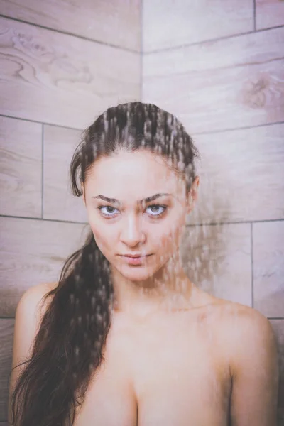 Jeune femme belle sous la douche dans la salle de bain . — Photo