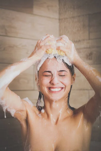 Jonge beautyful vrouw onder de douche in de badkamer. — Stockfoto