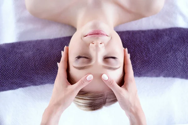 Jeune femme allongée sur une table de massage, relaxante les yeux fermés. Femme. Salon de spa — Photo