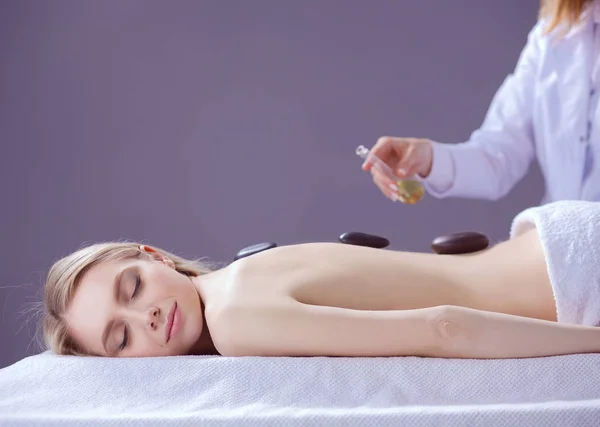 Mujer joven acostada en una mesa de masaje, relajándose con los ojos cerrados. Una mujer. Salón de spa — Foto de Stock