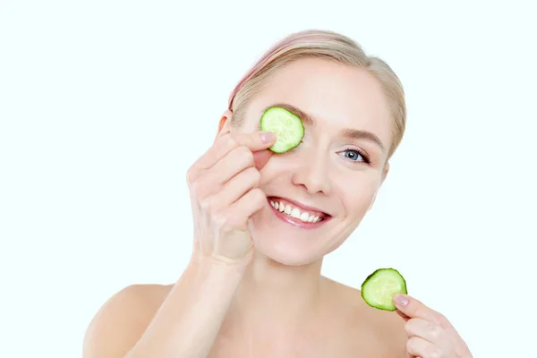 Joven hermosa mujer con rodajas de pepino sobre fondo blanco —  Fotos de Stock