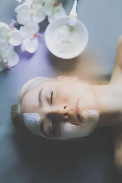 Mascarilla facial. Hermosa joven en el spa, mujer cosmética aplicando mascarilla facial —  Fotos de Stock