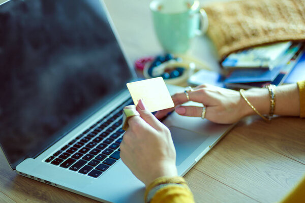 Молодая женщина с кредиткой и ноутбуком. Концепция покупок